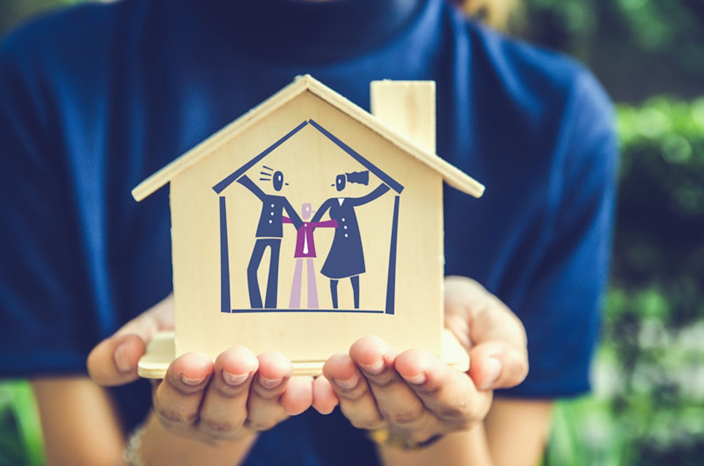 hands holding small house